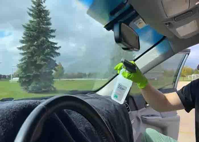 Spraying alcohol to your windshield to clean it