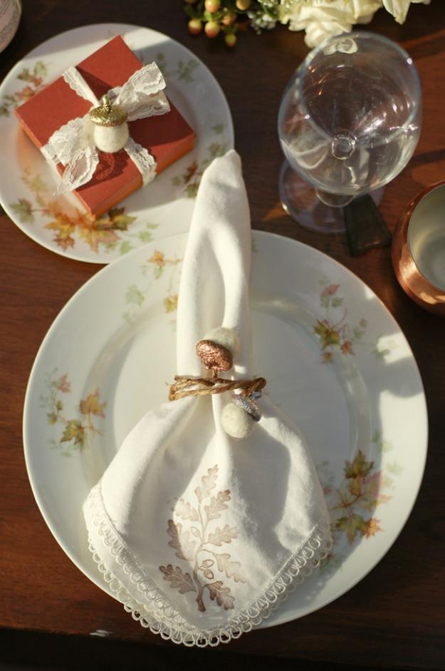Felt acorn napkin rings made from felt balls glued onto a vine style floral wire ring on a fall table setting