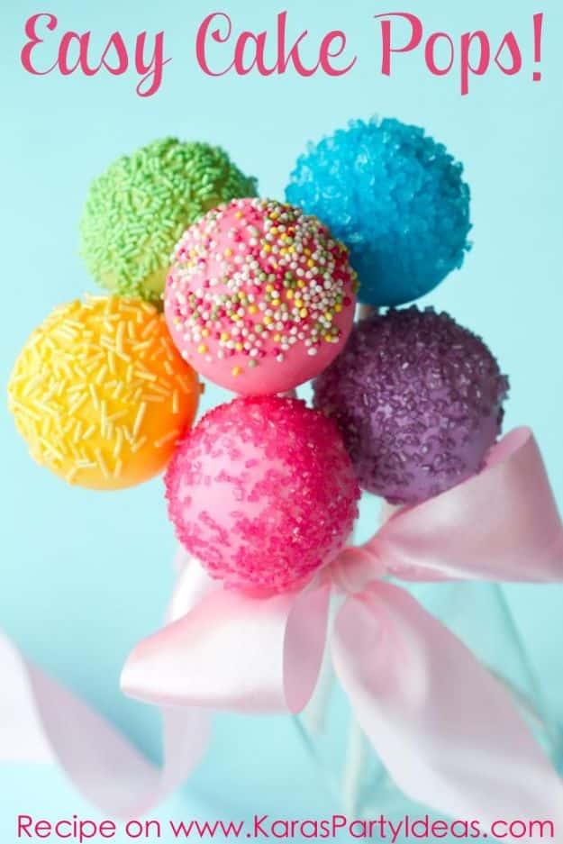 Easy cake pops dipped in colored candy coating and sprinkles, standing in a cake pop stand to set, a simple party dessert