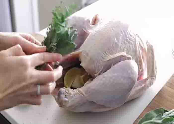 Stuffing the turkey with onions, lemons, and herbs