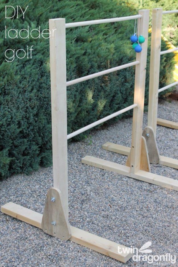 DIY ladder golf game with wooden uprights and three dowel rungs, bolas hanging from the top rung beside a hedge
