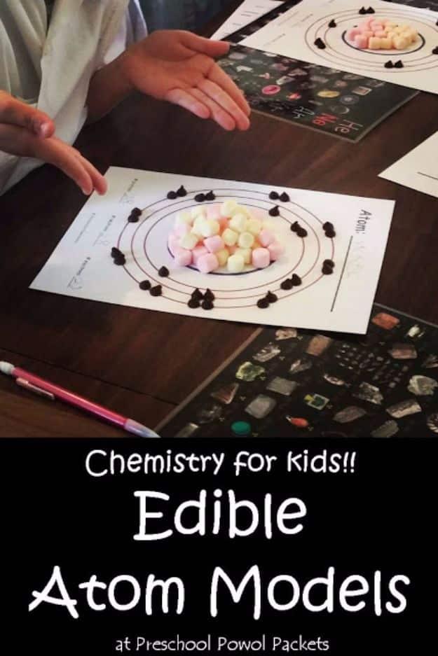 Edible atom models, a printed atom diagram on a dark table with marshmallows as the nucleus and chocolate chips on the rings