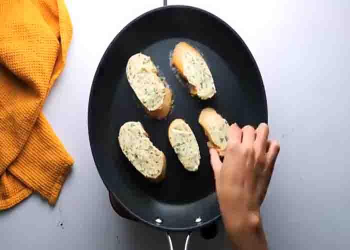 Toasting the garlic bread in the stovetop.