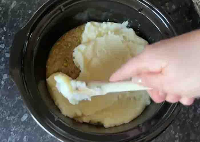 Placing the mashed potato on top of the shepherd's pie