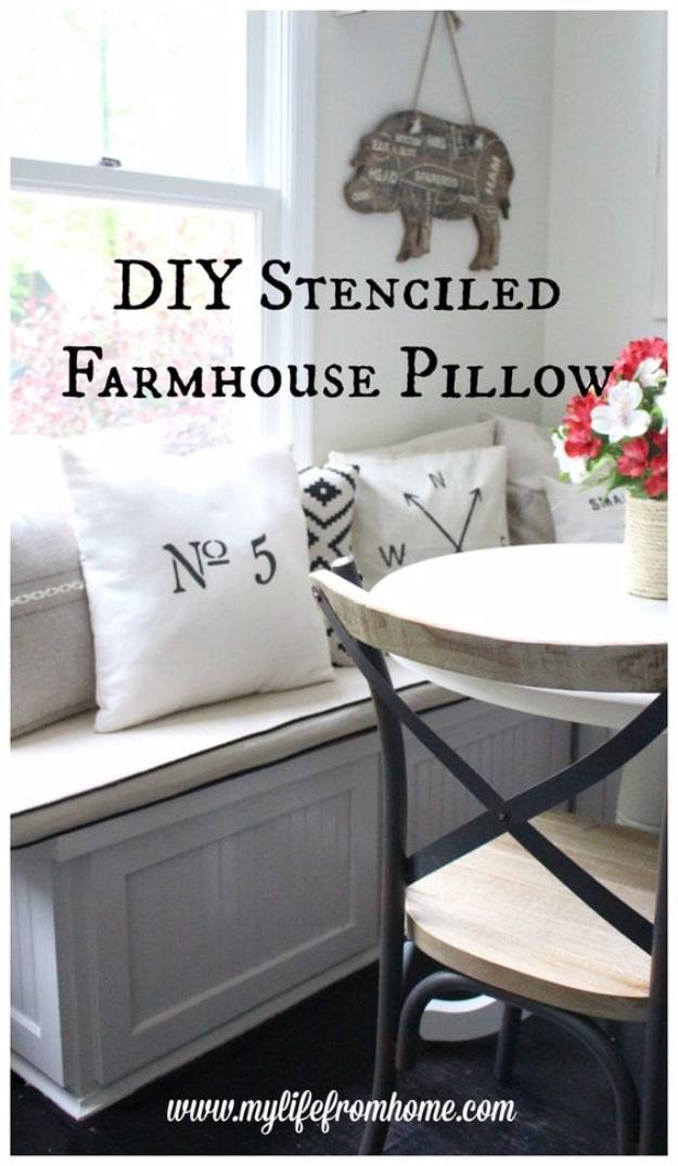 Farmhouse stenciled pillow, a white pillow cover with a large black number five stenciled on it on a window bench