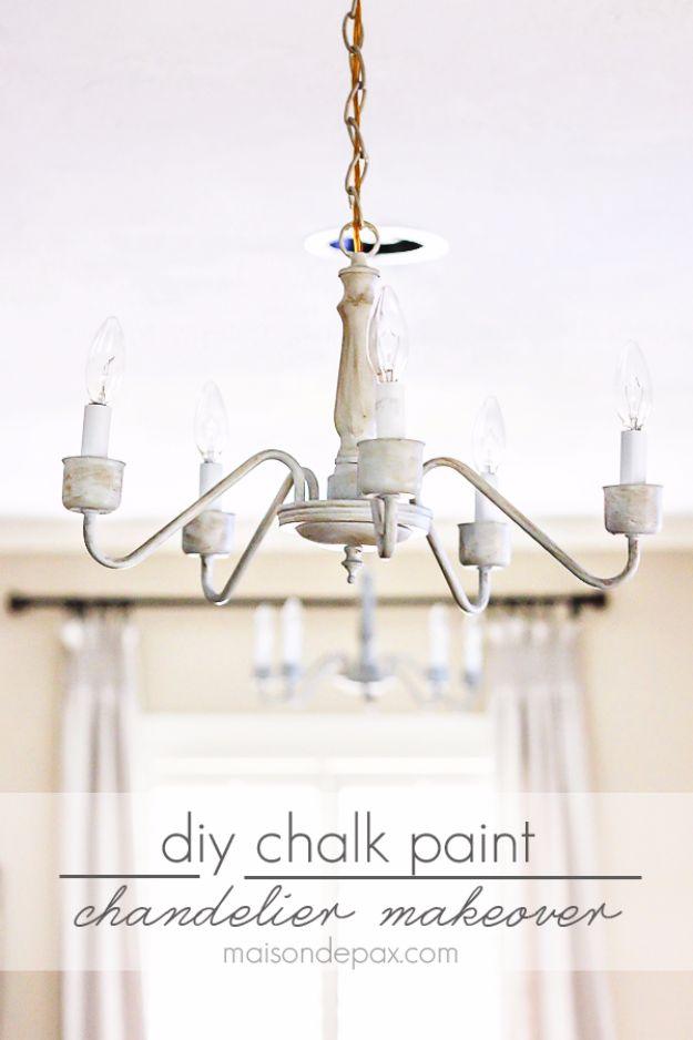 Chalk painted chandelier makeover in soft white with drip candle sleeves, hanging beside pale curtains