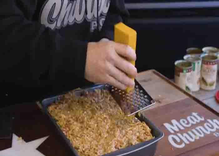 Adding shredded cheese on top of the king ranch casserole
