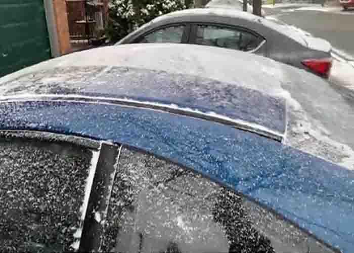 Cleaning snow off the hood of the car