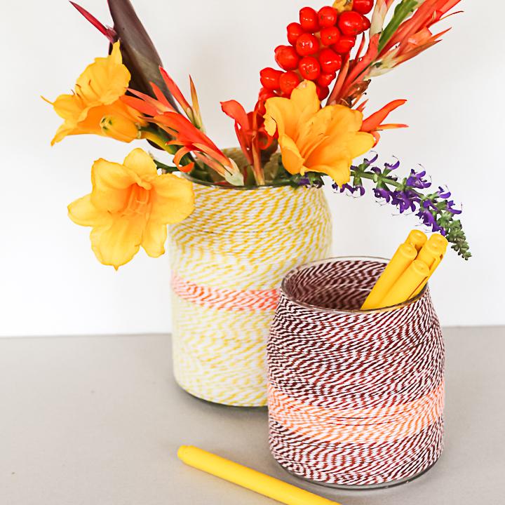 Twine wrapped vases, two jars bound in cream, orange and red bakers twine, one of flowers and one of yellow craft sticks