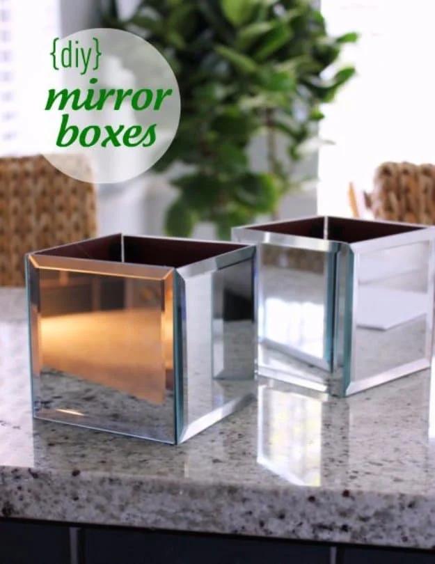 A small wooden cube faced on every side with beveled mirror tiles, holding a trailing green ivy on a pale wood shelf