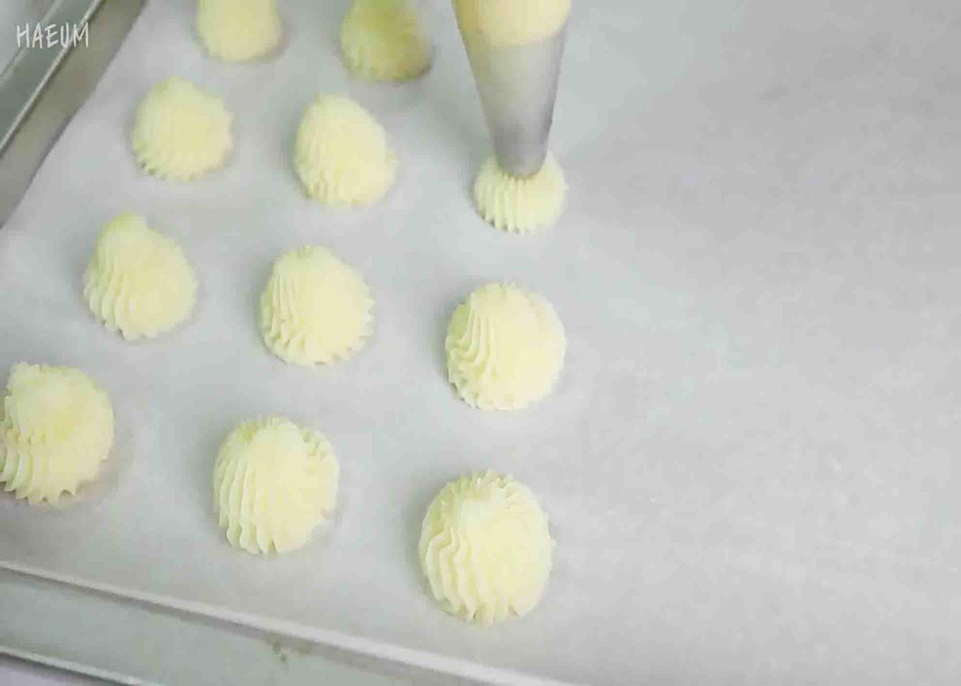 Piping the mashed potato in a baking tray, ready to bake.