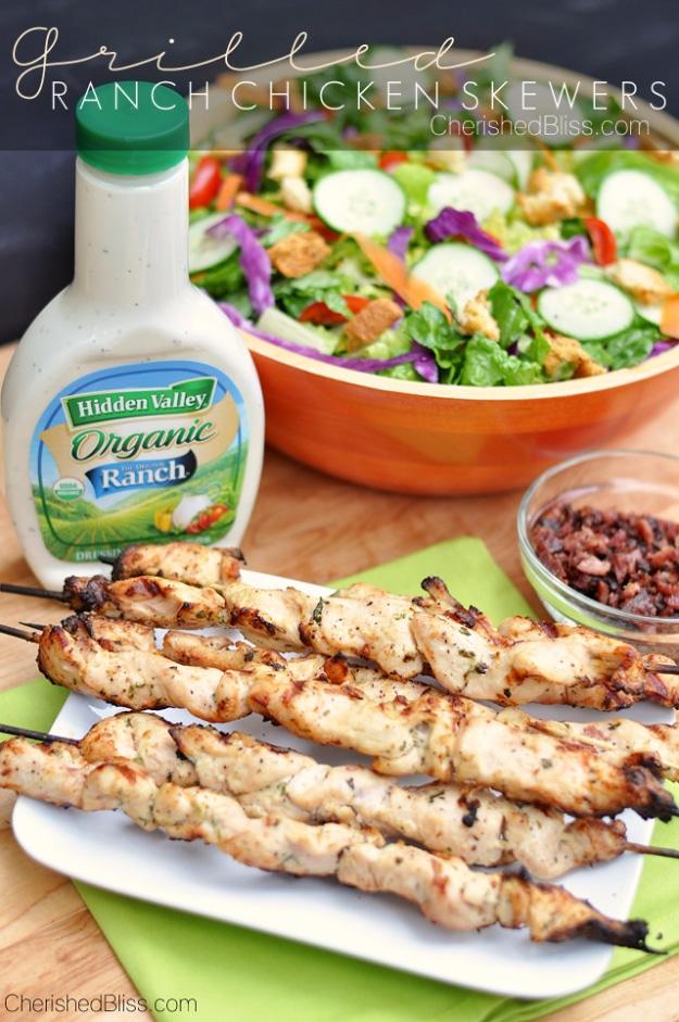 Grilled ranch chicken skewers on a platter, flecked with fresh parsley and chives off the grill on a cookout table
