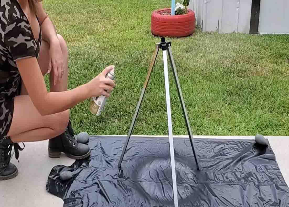Spraying some gold paint to the old tripod for the DIY side table
