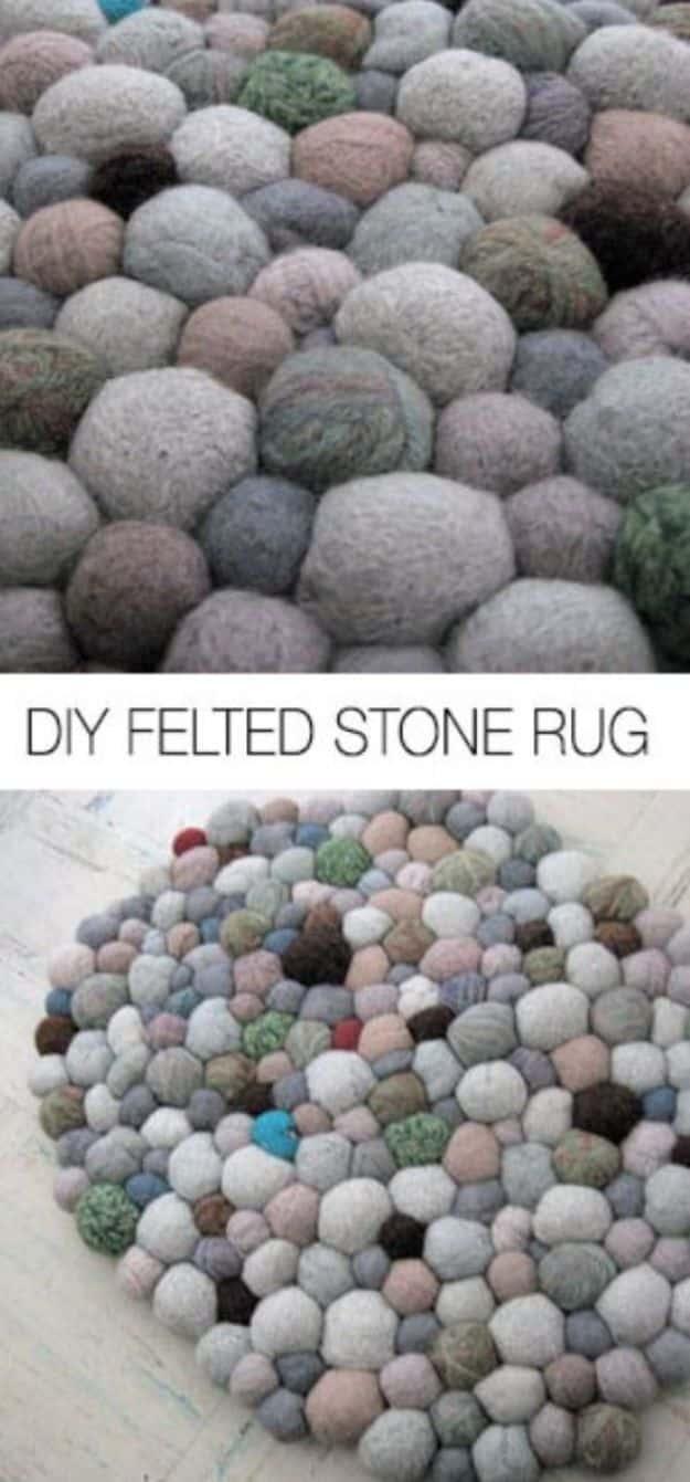 Round DIY felted stone rug made from hundreds of wool balls in grey, cream, pink and green stitched like pebbles