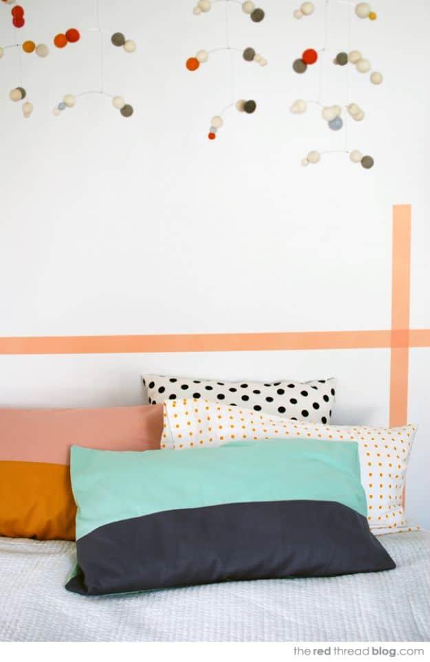 A color block pillowcase in cream cotton with a navy contrast band, smoothed flat across a neatly made bed.