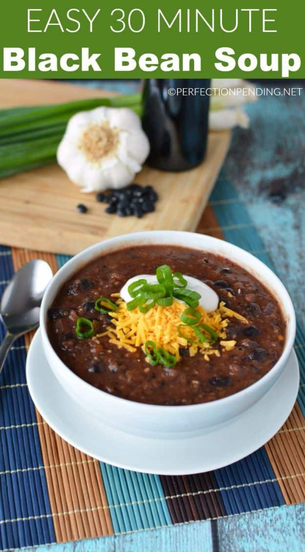 Easy black bean soup in a bowl topped with Greek yogurt, sliced green onion and shredded cheddar cheese