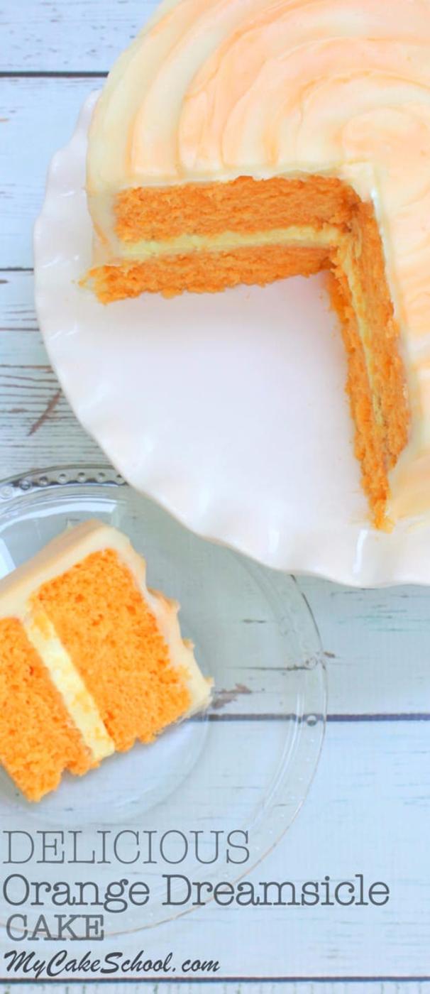 Orange dreamsicle layer cake with pale orange and white swirled frosting and one slice cut and plated