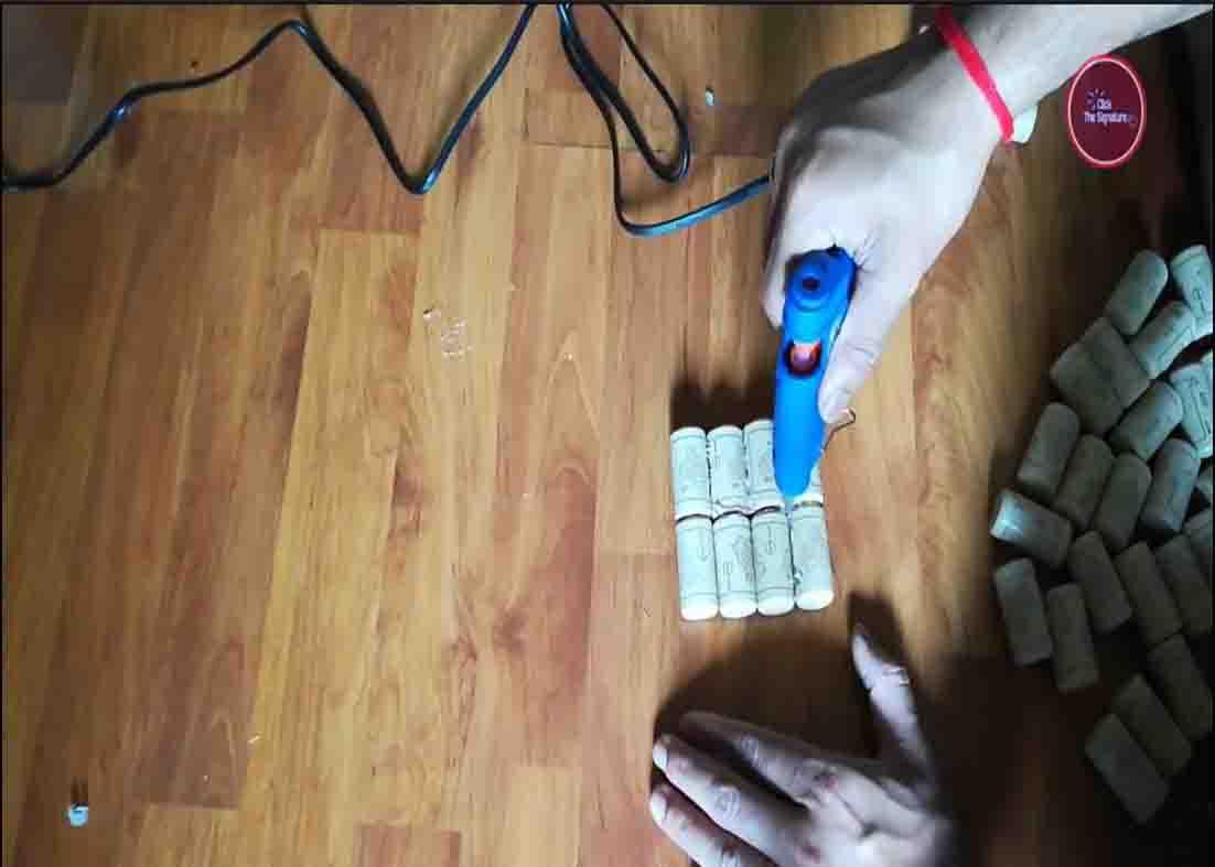 Gluing the corks together to form the wall of the flower vase