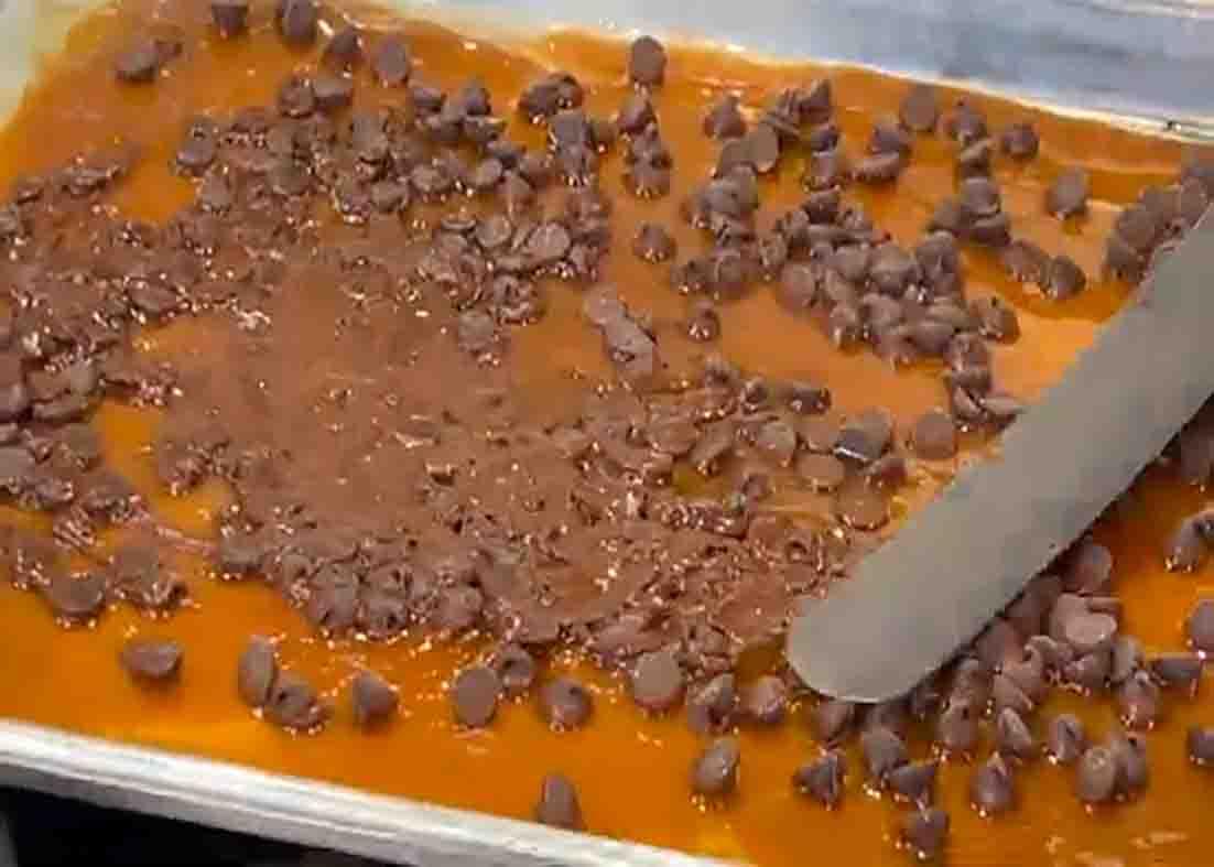 Spreading the chocolate over the toffee