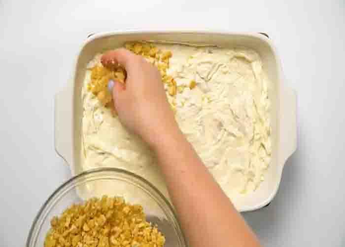 Topping the chicken casserole with crushed Ritz crackers