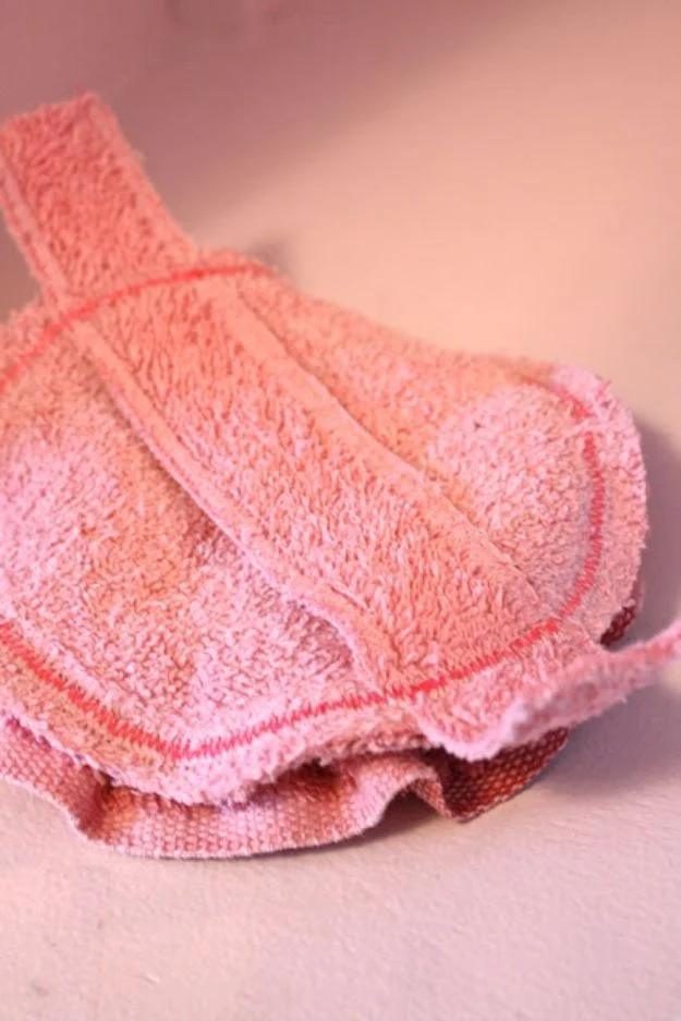 Old towel bath pouf made from a pink terry strip gathered and sewn in a spiral so it looks like a rose