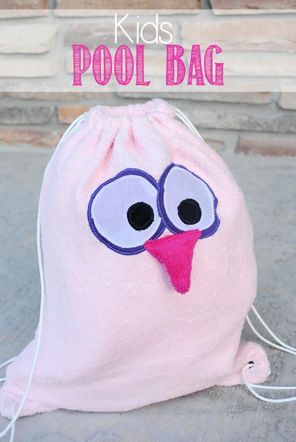 A kid sized drawstring bag in bright cotton with a hem casing and cord, packed for the pool on a craft fair table
