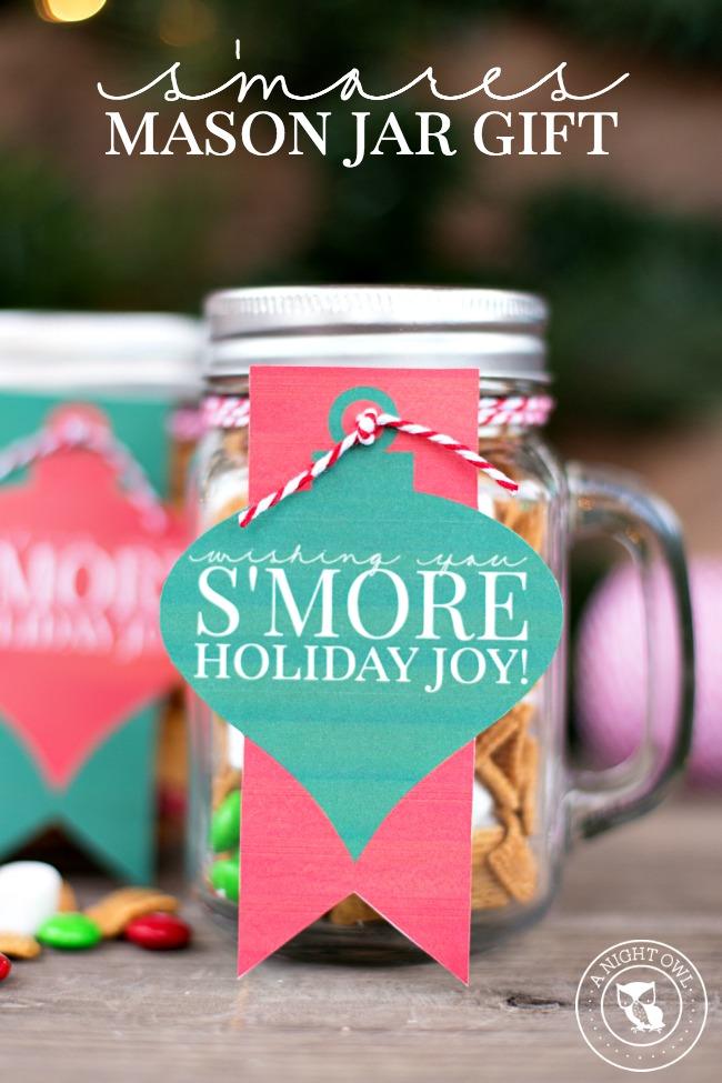 Mason jar with a handle packed with s'mores snack mix of cereal, candies and mini marshmallows and a gift tag