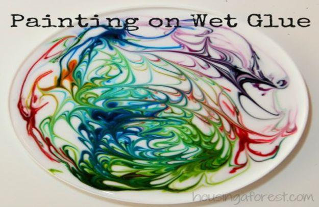 Swirled rainbow food coloring marbled through white glue on a round white plate, under a typeset Painting on Wet Glue title