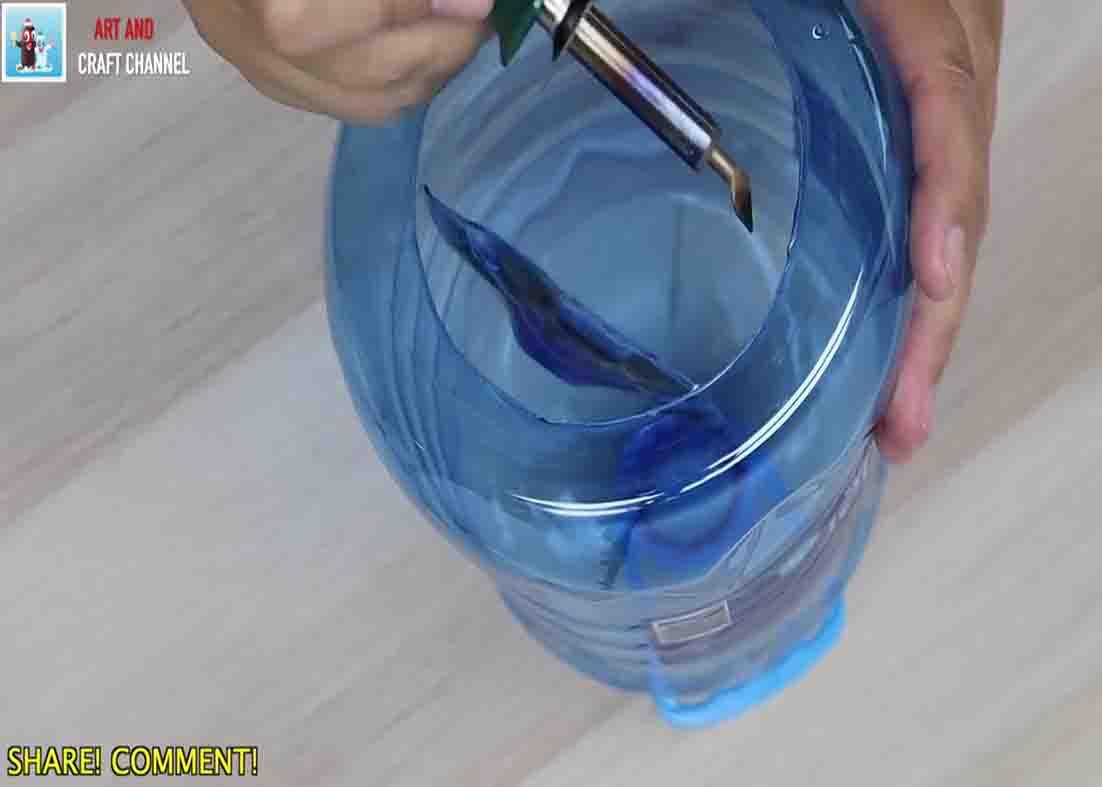 Cutting the bottom of the plastic bottle open for the toilet paper roll