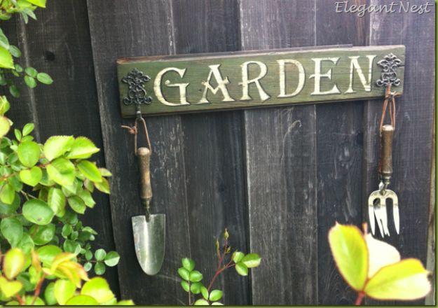 A weathered hand lettered board hung on a fence by wire, chipped paint and worn edges, country crafts with real age