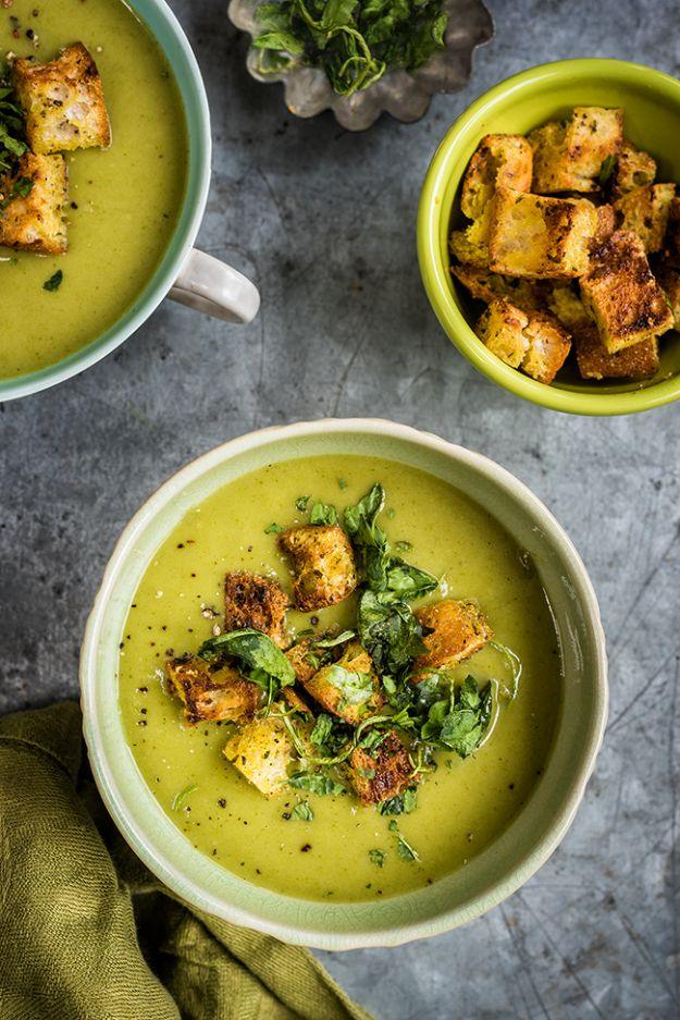 Spinach coconut zucchini soup in green bowls, bright green with herbed croutons scattered over the top