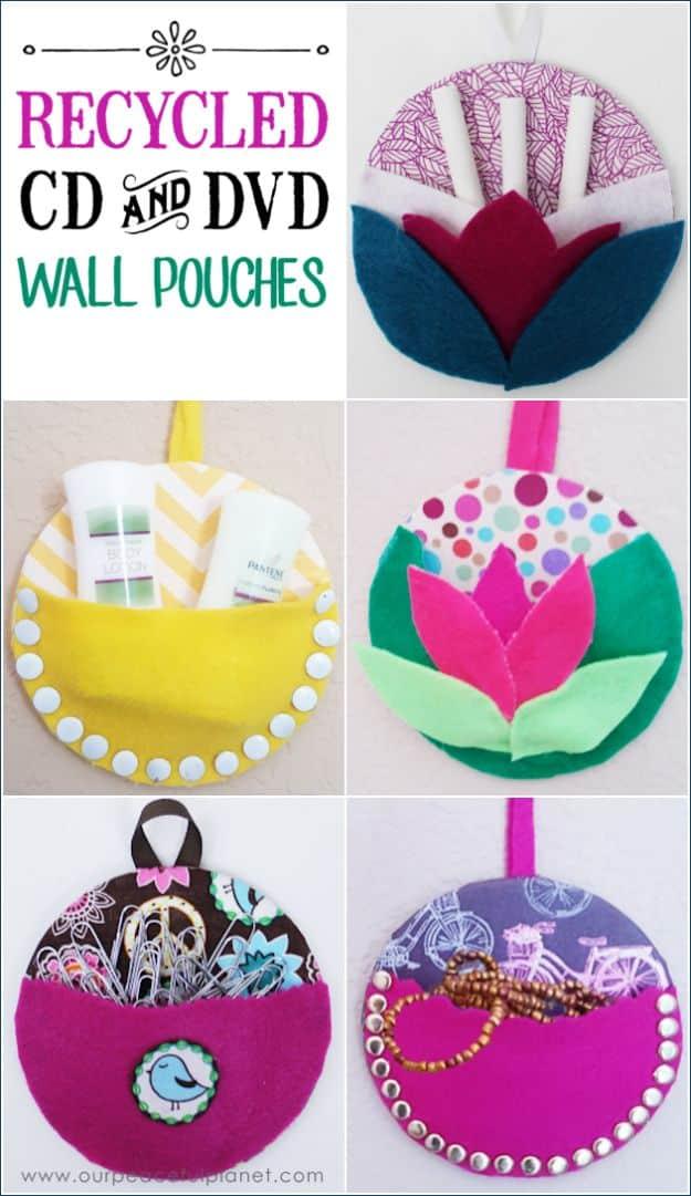 Five wall pouches made from CDs covered in felt in yellow, pink, purple and teal, with a typeset pin title