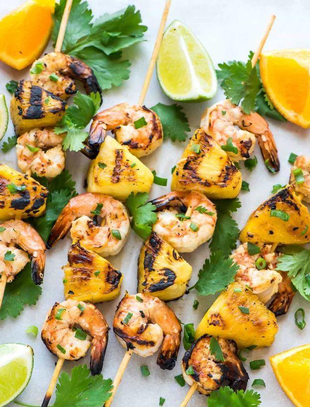 Grilled coconut pineapple shrimp skewers with charred pineapple, cilantro and lime and orange wedges