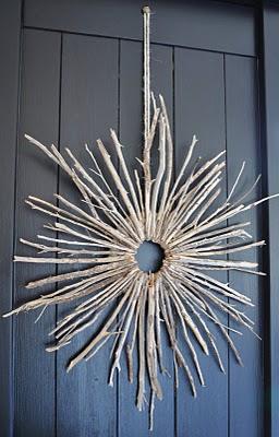 Starburst wreath of bare twigs radiating out from the center, a modern autumn wreath for a plain door