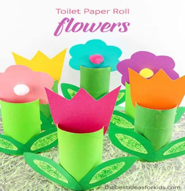 Six paper roll flowers, three pointed tulips and three round blooms with pom pom centers, on green bases and leaves