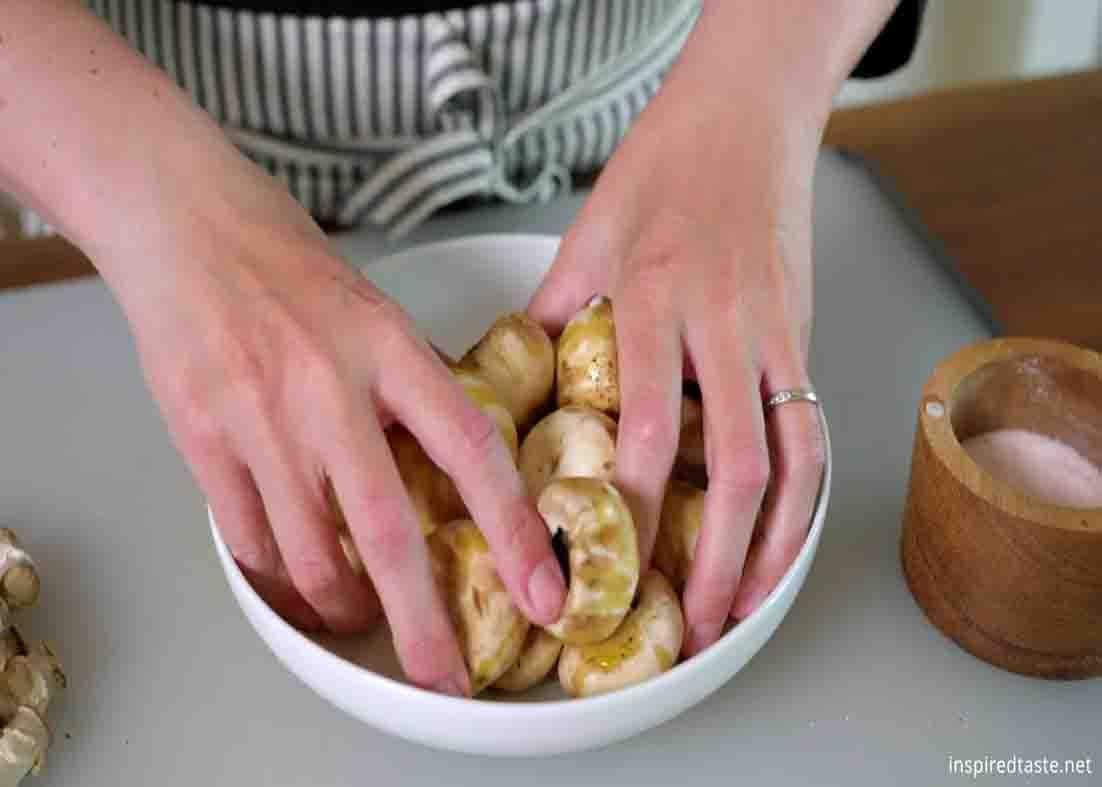 Coating the mushrooms with olive oil and herbs