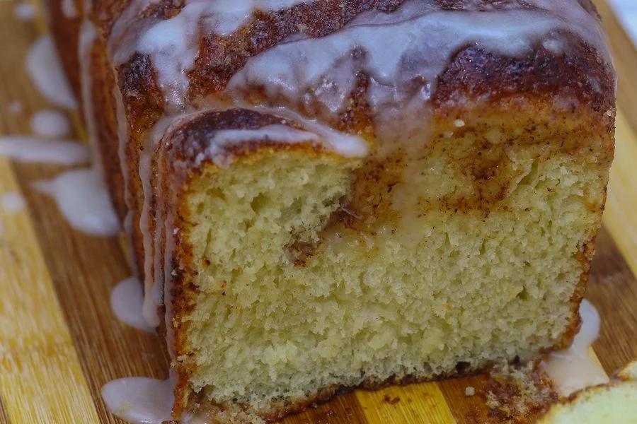 Close up of homemade cinnamon bread with glaze dripping down the side