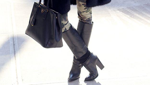 Weather proof leather boots, tall black leather riding boots worn on a sidewalk with a black handbag