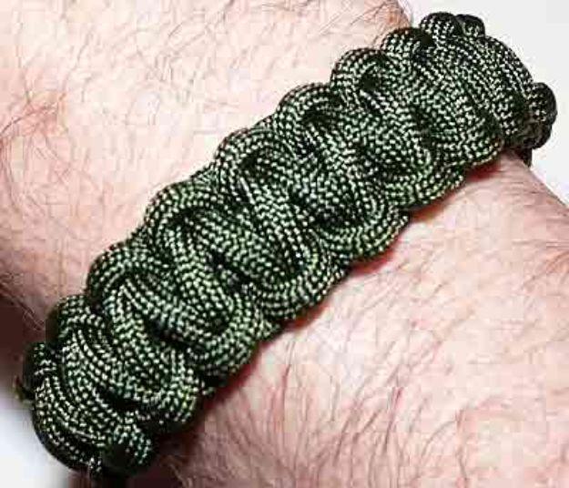 Single color olive green cobra braid paracord bracelet worn on a wrist, showing an even consistent weave