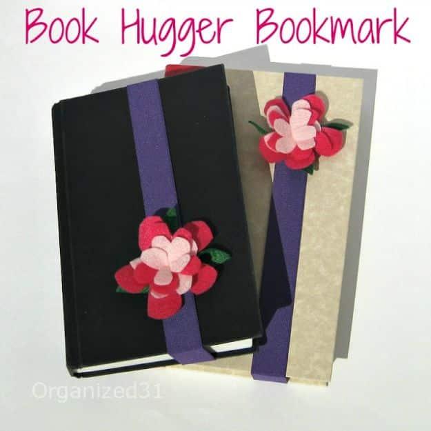 Graphic titled Book Hugger Bookmark over a black and a cream notebook banded in purple elastic with red felt flowers