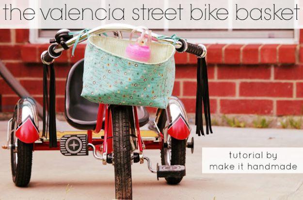 Mint fabric bike basket with black fringe, tied to a red tricycle's handlebars, under a typeset tutorial title