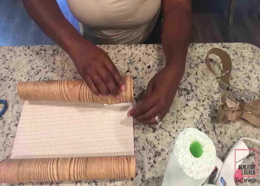 Wrapping the pool noodle with faux wood liner to make the DIY LED candles