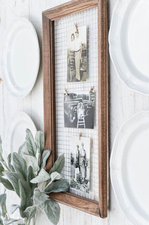 Long narrow dark wood frame backed with wire hardware cloth holding three vintage black and white photos on tiny clothespins
