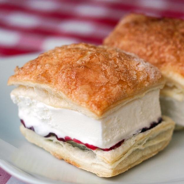 Raspberry vanilla puff pastry ice cream sandwiches on a board, a make ahead frozen dessert idea for parties