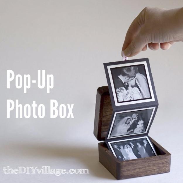 A small cardstock box opened out into standing panels of family photographs, tied shut with thin ribbon