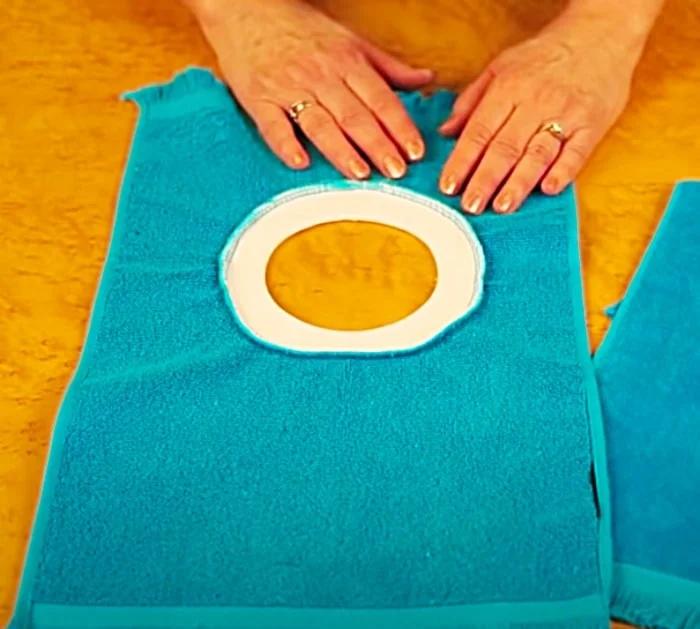 Cut a circle in a hand towel to make a pullover baby bib
