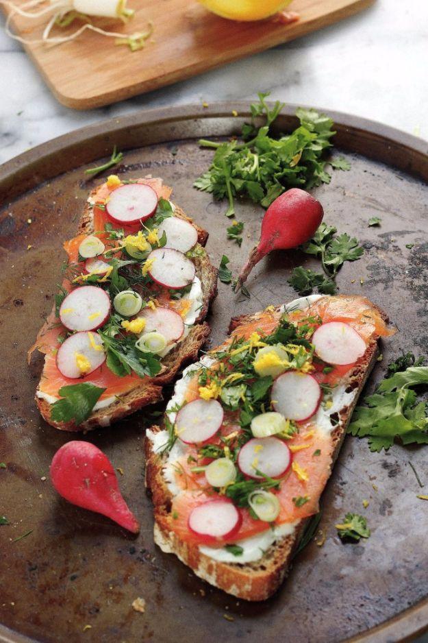 Smoked salmon tartine on toast with wasabi yogurt spread, sliced radishes, dill, parsley and lemon zest