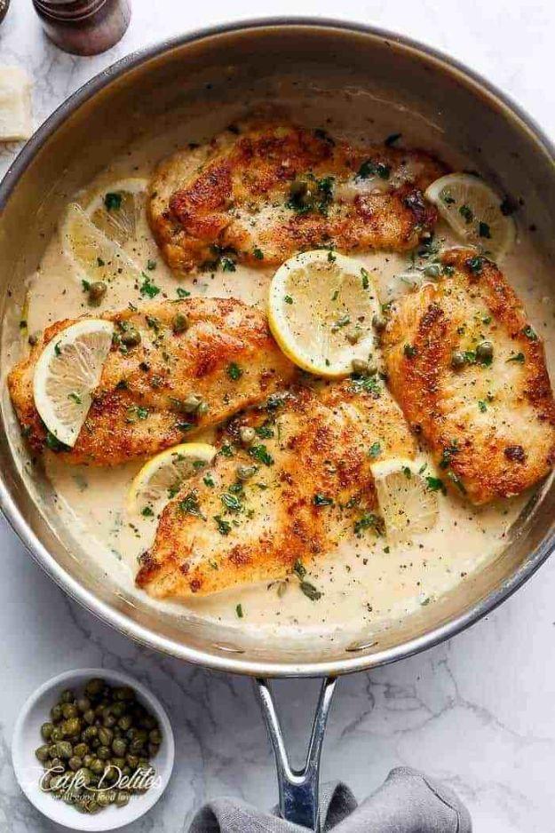 Creamy lemon parmesan chicken piccata in a cast iron skillet with capers and a thick lemon cream pan sauce
