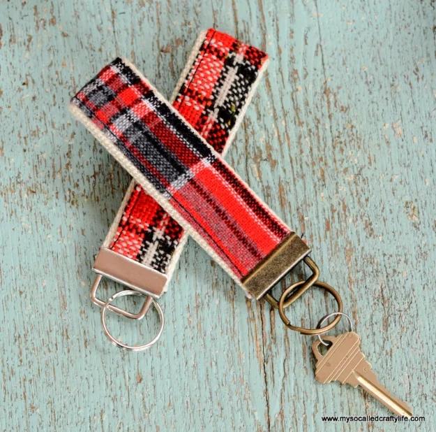 Key fobs made from vintage wool and cotton fabric scraps, clamped onto silver hardware and hung on a wooden peg rail