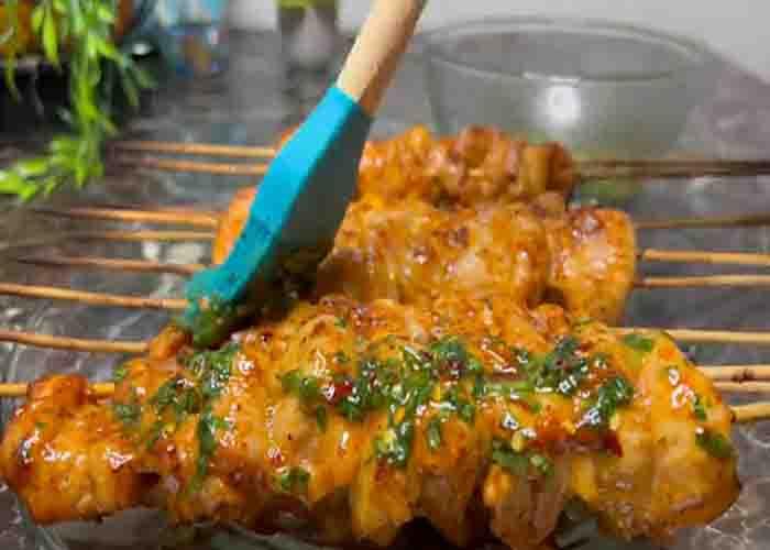 Brushing some butter to the chicken skewers